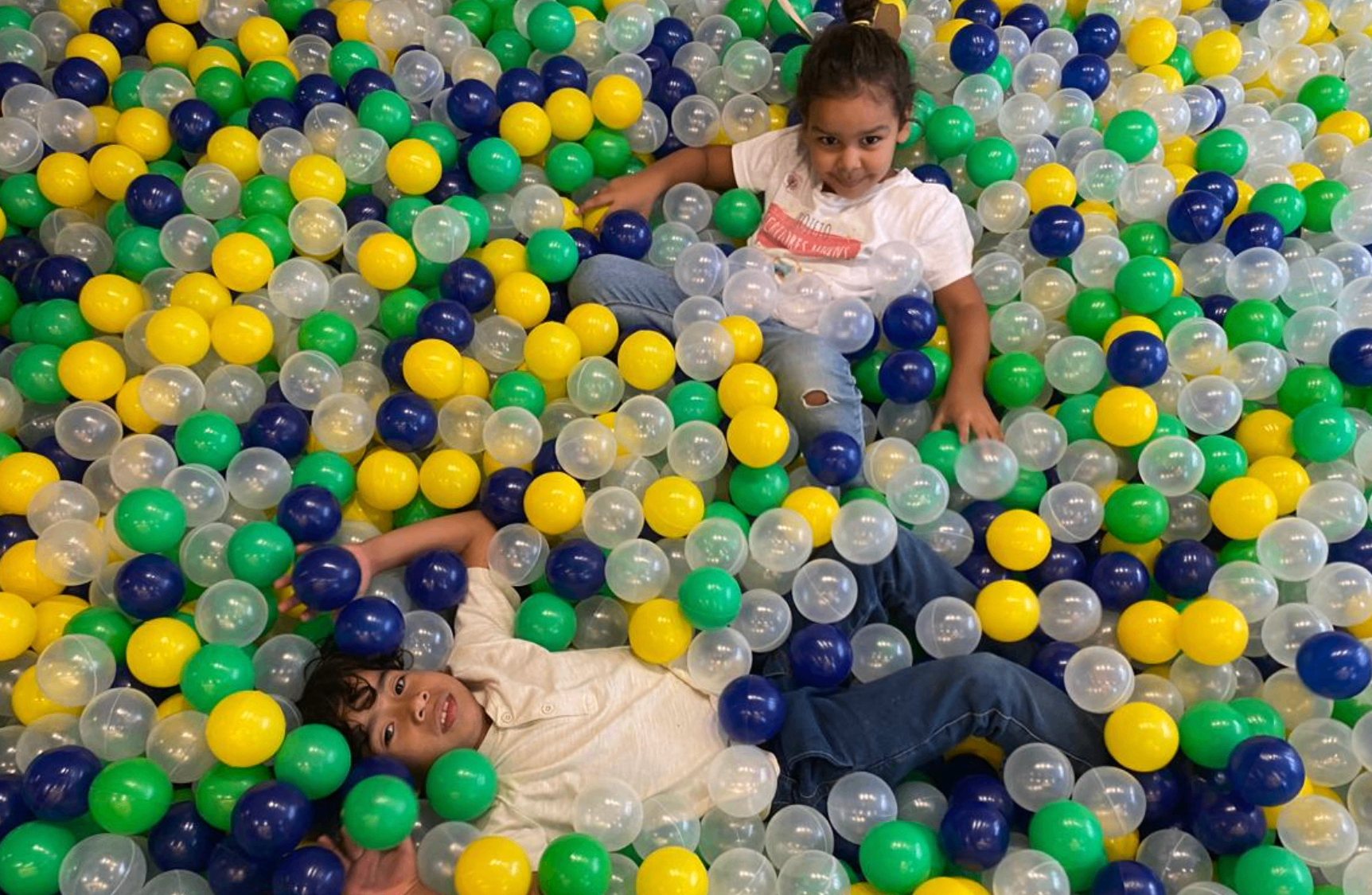 Crianças brincando na piscina de bolinhas