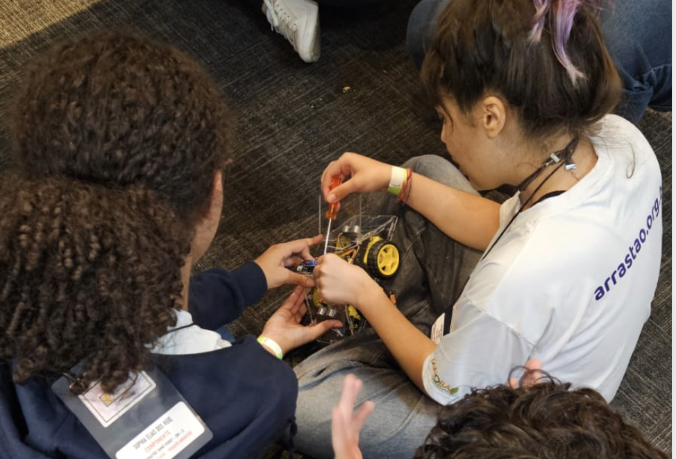 Jovens montando robô em oficina de robótica