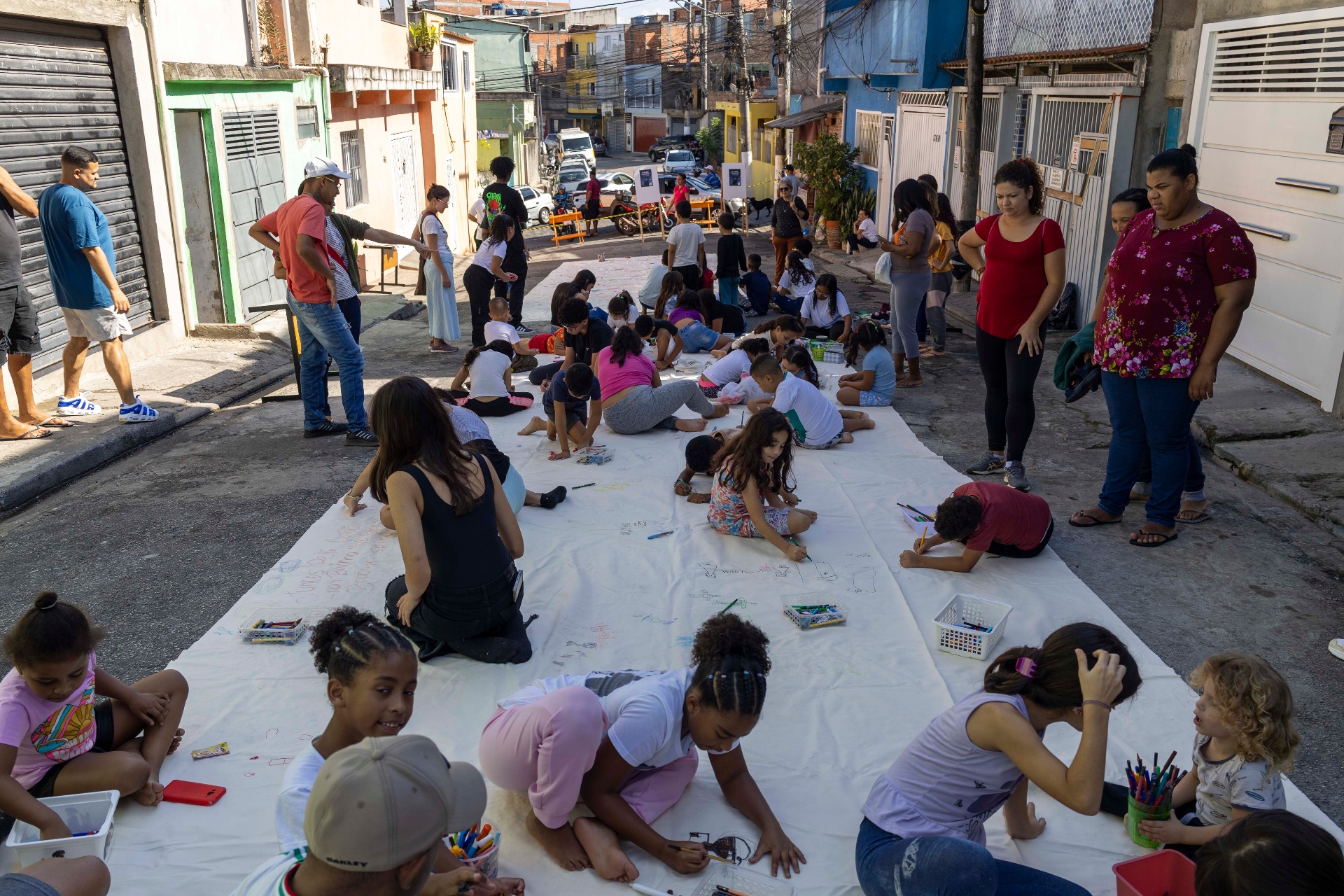 Crianças desenhando na rua durante vivência educativa